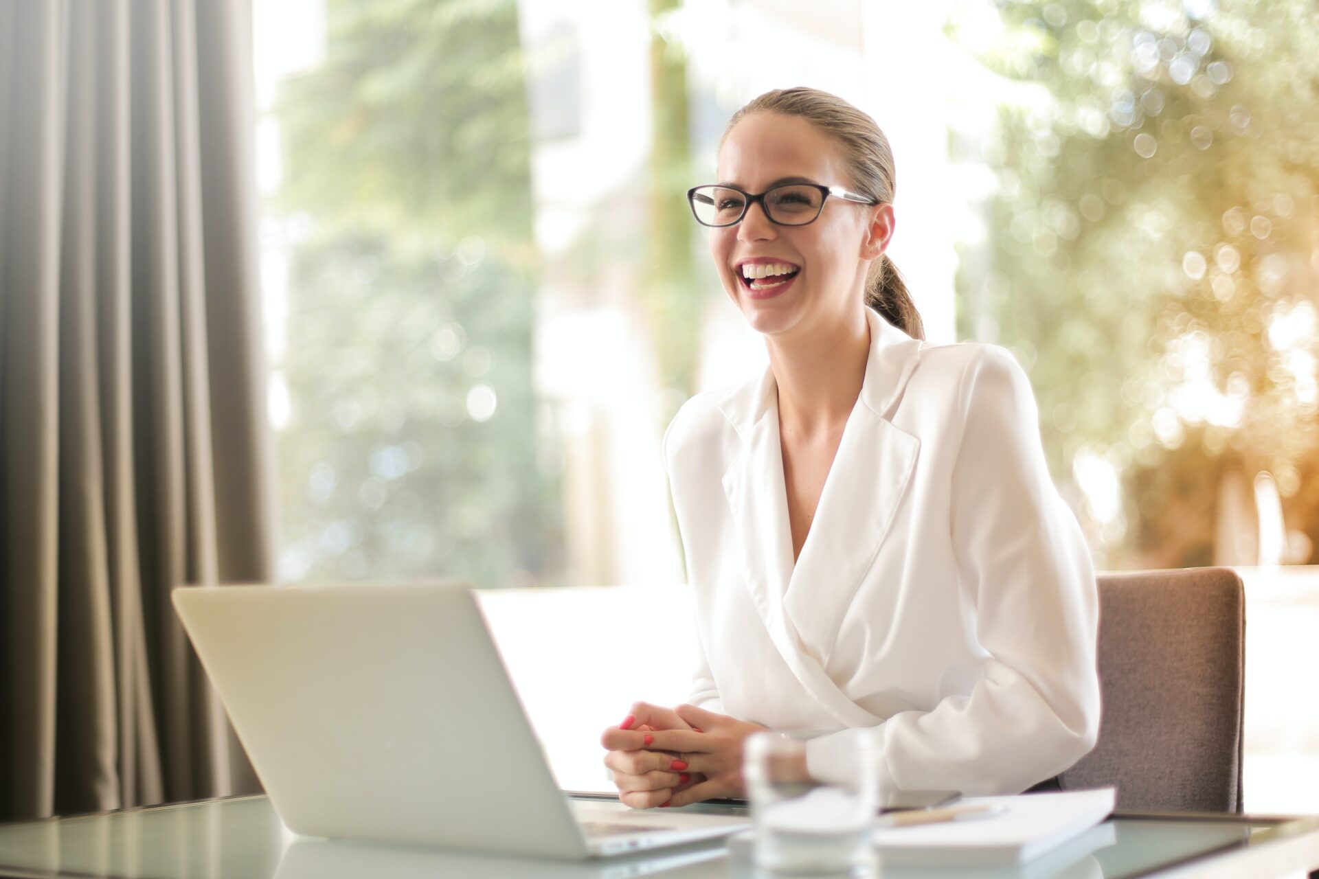 Smiling woman studying real estate continuing education on her computer in a home environment