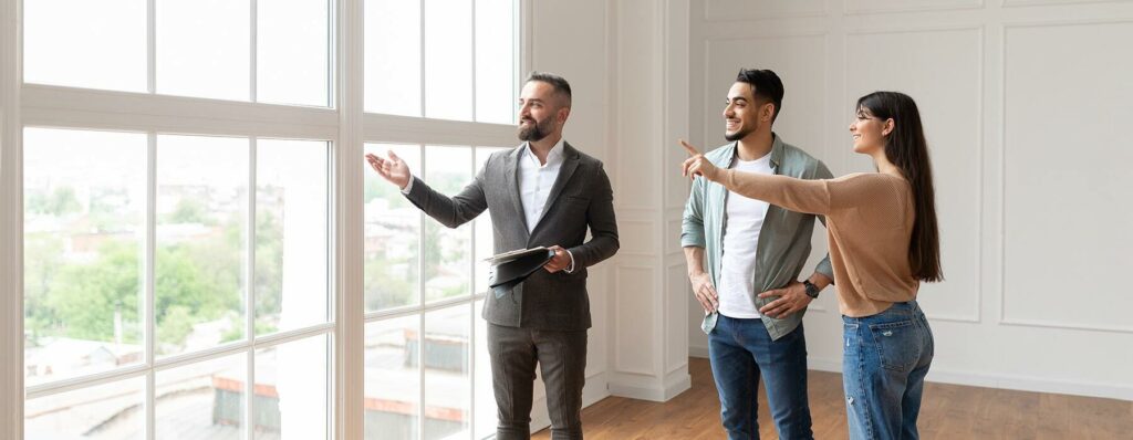 real estate agent showing young buyers new property